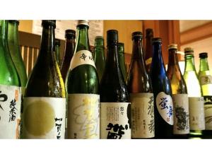 a group of bottles of wine sitting on a shelf at Yamashiro Onsen Yuzankaku - Vacation STAY 86432v in Kaga