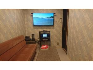 a living room with a couch and a flat screen tv at Yamashiro Onsen Yuzankaku - Vacation STAY 86432v in Kaga