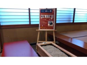 un cartello in una stanza con tavolo e panca di Yamashiro Onsen Yuzankaku - Vacation STAY 86430v a Kaga