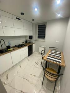 une cuisine avec des armoires blanches et une table et des chaises dans l'établissement Apartament ,,Eden”, à Zator 2 autres photos