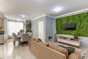 uma sala de estar com um sofá e uma parede verde em Apartamento 2 quartos com Spá Expocentro Praias em Balneário Camboriú