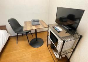 Habitación con mesa, silla y TV. en Beverly Homes Osaki Room 203, Room 205, Room 301, - Vacation STAY 89071v, en Tokio