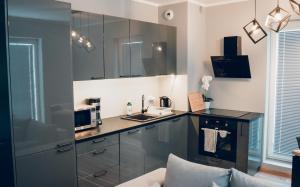 a kitchen with stainless steel cabinets and a microwave at Cosy Apartment-Marine in Rumia