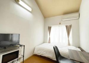 een slaapkamer met een bed, een televisie en een stoel bij Beverly Homes Osaki Room 203, Room 205, Room 301, - Vacation STAY 89062v in Tokyo