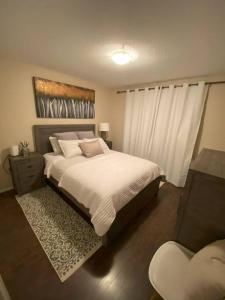 a bedroom with a large bed and a chair at Cozy Condo at the Lake in Sylvan Lake