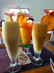 four drinks in glasses sitting on a table at Nila Beach Resort in Lautoka