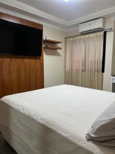 een slaapkamer met een groot bed en een flatscreen-tv bij APARTAMENTO EM EDIFICIO 100% MOBILIADO PARA TEMPORADA in Manaus