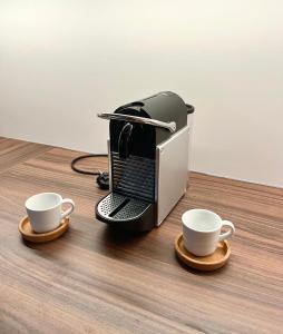 zwei Tassen Kaffee auf einem Tisch mit Drucker in der Unterkunft Altstadt Lounge Pirna in Pirna