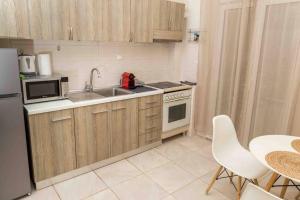 eine kleine Küche mit einer Spüle und einer Mikrowelle in der Unterkunft Simplicity Big Apartment in Thessaloniki