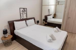 ein Schlafzimmer mit einem großen Bett und einem Spiegel in der Unterkunft Simplicity Big Apartment in Thessaloniki