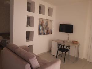 ein Wohnzimmer mit einem Sofa und einem Tisch in der Unterkunft Il Giglio Bianco in Adelfia