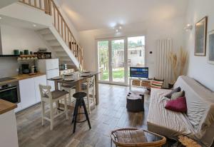eine Küche und ein Wohnzimmer mit einem Sofa und einem Tisch in der Unterkunft Le Woody Lodge, Large cottage with wooden deck and chalet with garden view next to Fontainebleau Forest in Achères-la-Forêt