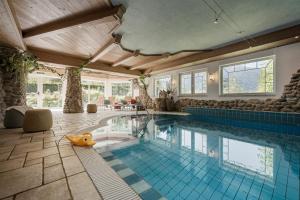 a large swimming pool in a house with a swimming pool at Biohotel Rastbichlhof in Neustift im Stubaital