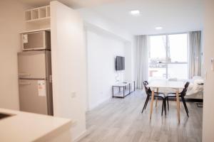 a kitchen and dining room with a table and a refrigerator at WeSleep Paraguay Departamentos en Microcentro in Buenos Aires