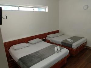 2 Einzelbetten in einem Zimmer mit Fenster in der Unterkunft HOTEL SENSACIONES SUITE in Medellín