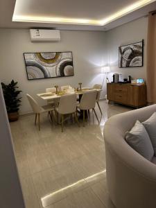 Hotel Apartment -7- L'Avner Al Moteab في الرياض: غرفة طعام مع طاولة وكراسي وأريكة