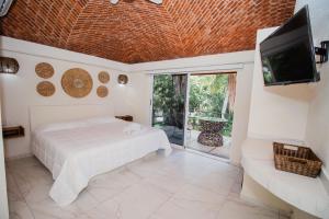 a bedroom with a bed and a flat screen tv at Paulas Suites Terraza in Ixtapa +22 photos