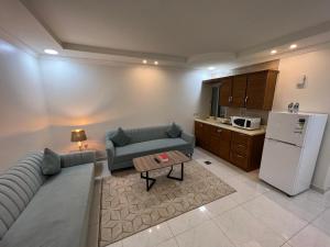 a living room with a couch and a refrigerator at ليالي الشرقية لشقق المخدومة in Dammam