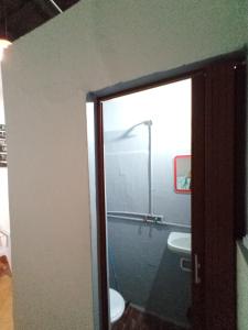 a bathroom with a toilet and a glass door at La Borgoña (Hostal) in Salta