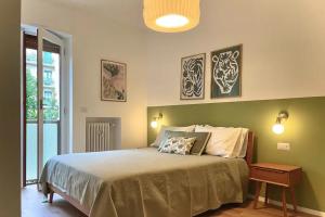 1 dormitorio con 1 cama grande y 2 cuadros en la pared en Luxury 2 bedroom Apartament, close to San Siro, Fiera and 10 min metro to Duomo, en Milán