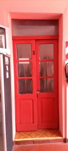 una porta rossa con scaffali in una stanza di La Borgoña (Hostal) a Salta