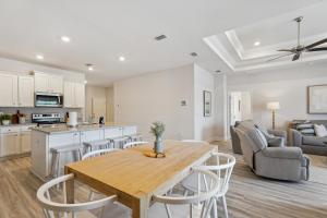 Highland ViewにあるPort St Joe Escape with Golf Cart and Pool Accessの木製のテーブルと椅子のあるキッチンとリビングルーム