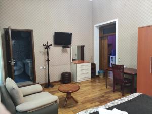 uma sala de estar com um sofá, uma mesa e uma televisão em ALMOS em Dushanbe