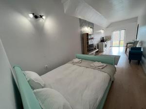a bedroom with a bed and a living room at Compact House in Cluj-Napoca