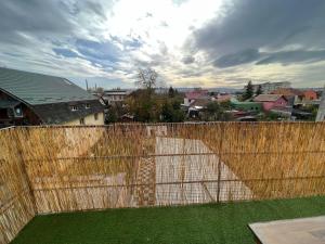 a wooden fence with a yard of grass at Compact House in Cluj-Napoca