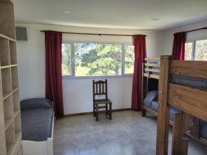 a bedroom with a bunk bed and a chair and a window at Casa a estrenar en Santa Elena - Santa Clara, Costa Atlantica in Playa Dorada