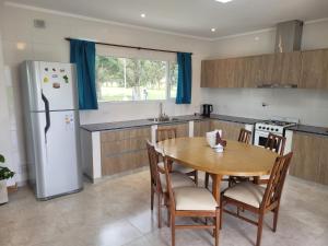 a kitchen with a wooden table and a refrigerator at Casa a estrenar en Santa Elena - Santa Clara, Costa Atlantica in Playa Dorada +10 photos