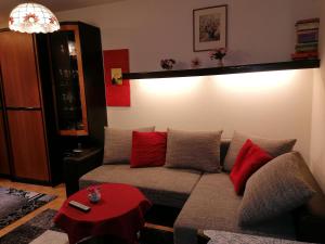 ein Wohnzimmer mit einem Sofa und roten Kissen in der Unterkunft Appartement Sonja Nassfeld in Sonnenalpe Nassfeld
