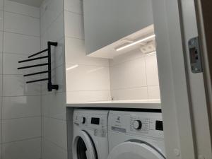 uma cozinha com uma máquina de lavar roupa na casa de banho em Cozy Room em Borås