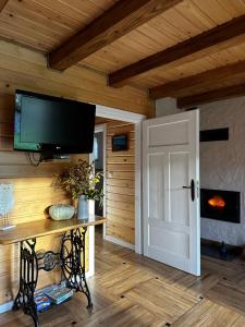 a room with a tv and a door and a table at Cabanówka in Hoczew