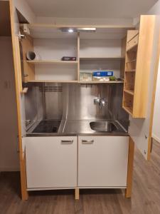 a small kitchen with white cabinets and a sink at leilighet med 2 soverom på kløfta in Klofta