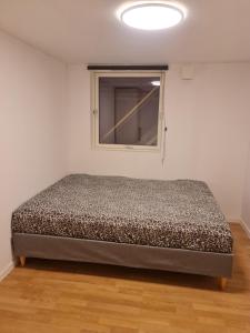 a bed in a room with a window at leilighet med 2 soverom på kløfta in Klofta