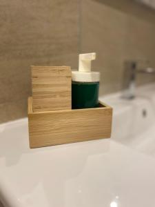 a wooden holder with a roll of toilet paper on a sink at La Dimora di Antonella in Naples +34 photos