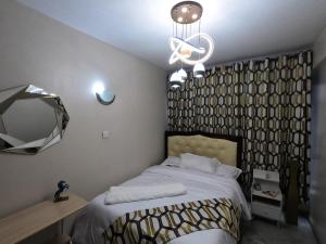 a bedroom with a bed and a mirror and a chandelier at A tastefully furnished one bedroom airbnb apartment along Thika rd, TRM mall in Nairobi