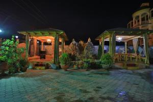 a stone patio with a pavilion at night at ALMOS in Dushanbe