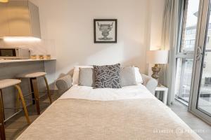 a living room with a couch and a kitchen at Vespasian's Abode by Grandeur Property in Poole