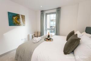 a white bedroom with a white bed and a window at Brand new town centre, sleeps 4 & WI-FI - Vespasian's Abode in Poole