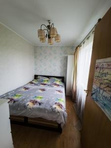 Un dormitorio con una cama con un edredón con pájaros. en Nikodema, en Krāslava