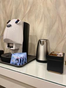 a coffee maker sitting on top of a counter next to a container at La Dimora di Antonella in Naples