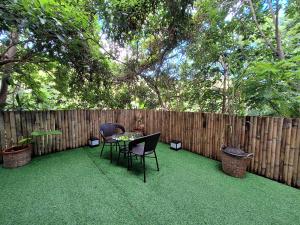 d'une terrasse avec une table, des chaises et une clôture. dans l'établissement Bali-style studio apartment, à Ban Madua Wan