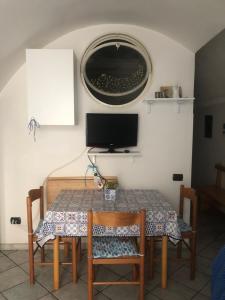 un tavolo con sedie e una televisione su una parete di La casa a mare a Cetara