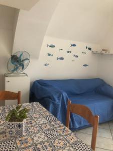 a room with a table and a bed with fish on the wall at La casa a mare in Cetara