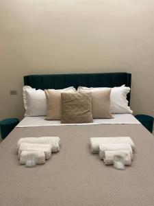 a bed with two pillows and two towels on it at La Dimora di Antonella in Naples
