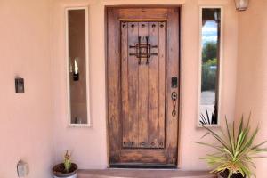 una puerta de madera de una casa con plantas delante en Southwestern Comfort Stay 2B en Las Cruces