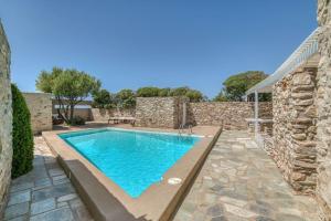 una piscina in un cortile con un muro di pietra di Villa Finca - Atypical a Pounda