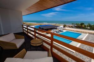 balcón con vistas a la piscina y al océano en Hotel Boutique Caleta Grau en Zorritos